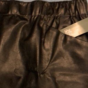 NWT black mini skirt looks like leather, but not.Elastic waist w/2 front pockets